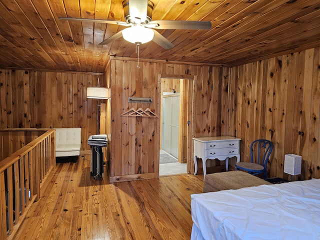 unfurnished bedroom with wooden ceiling, wooden walls, and hardwood / wood-style flooring