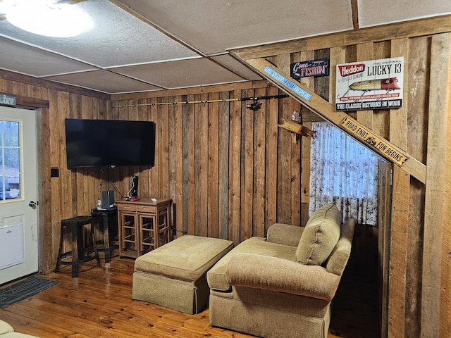 living room with hardwood / wood-style flooring and wooden walls