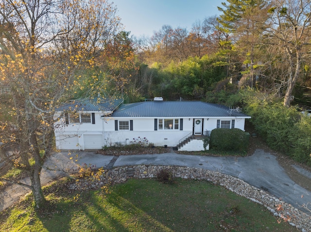 ranch-style house with a garage and a front lawn