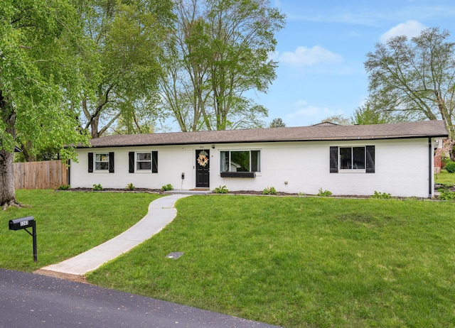 single story home with a front lawn and fence