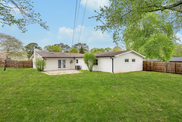 back of house with a patio, a fenced backyard, a lawn, a chimney, and french doors