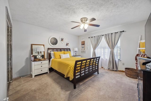 carpeted bedroom featuring a textured ceiling and ceiling fan