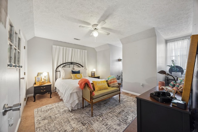 bedroom featuring carpet, a textured ceiling, vaulted ceiling, and ceiling fan