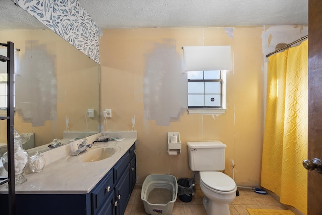 bathroom with toilet, a textured ceiling, vanity, and tile patterned floors