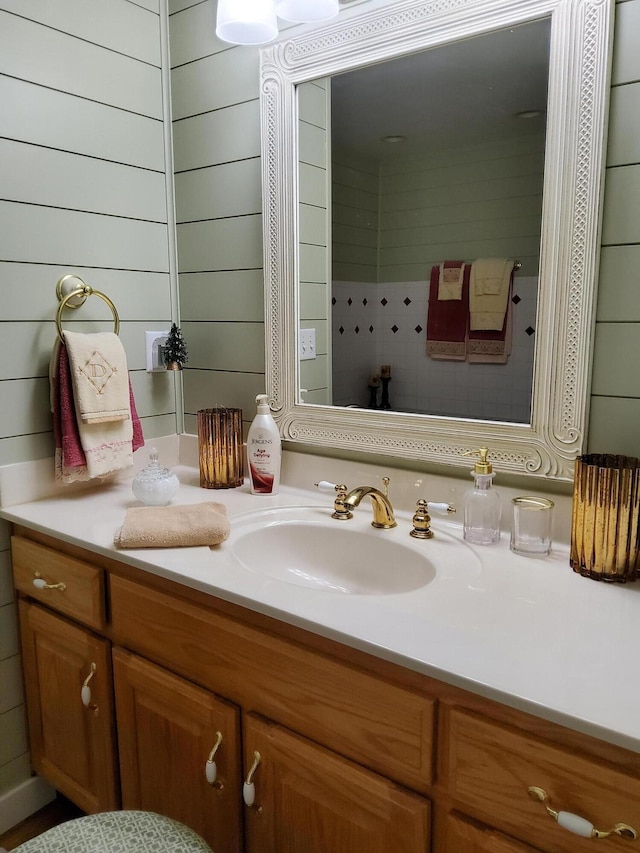 bathroom featuring vanity and wooden walls