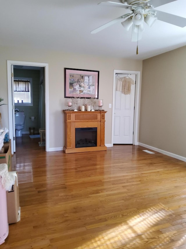 unfurnished living room with ceiling fan and wood-type flooring