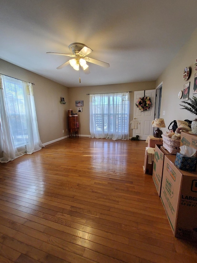 unfurnished living room featuring a healthy amount of sunlight, light wood finished floors, ceiling fan, and baseboards