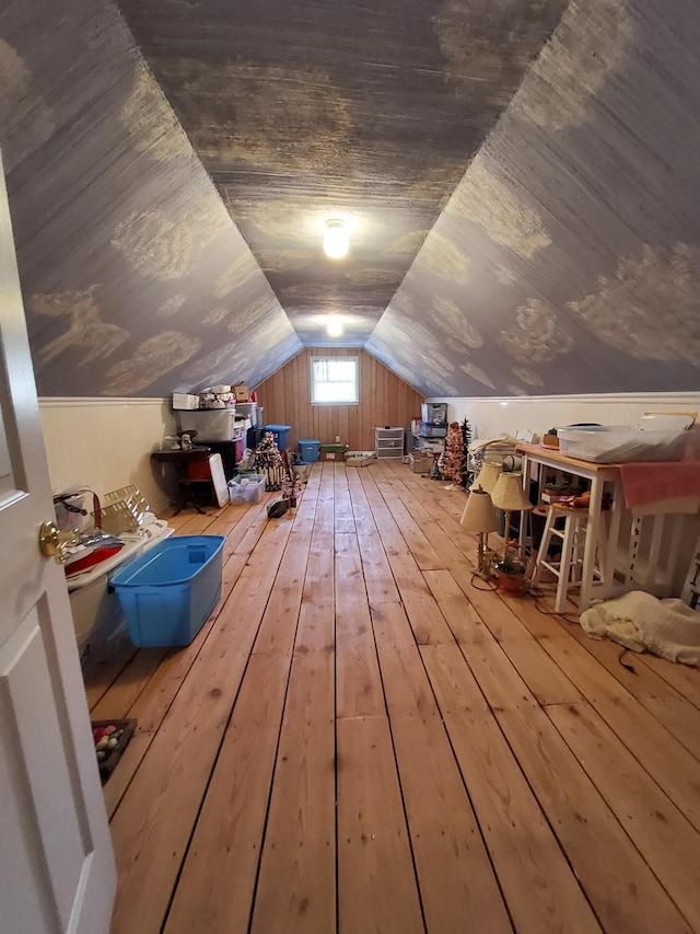 additional living space with wood-type flooring and vaulted ceiling