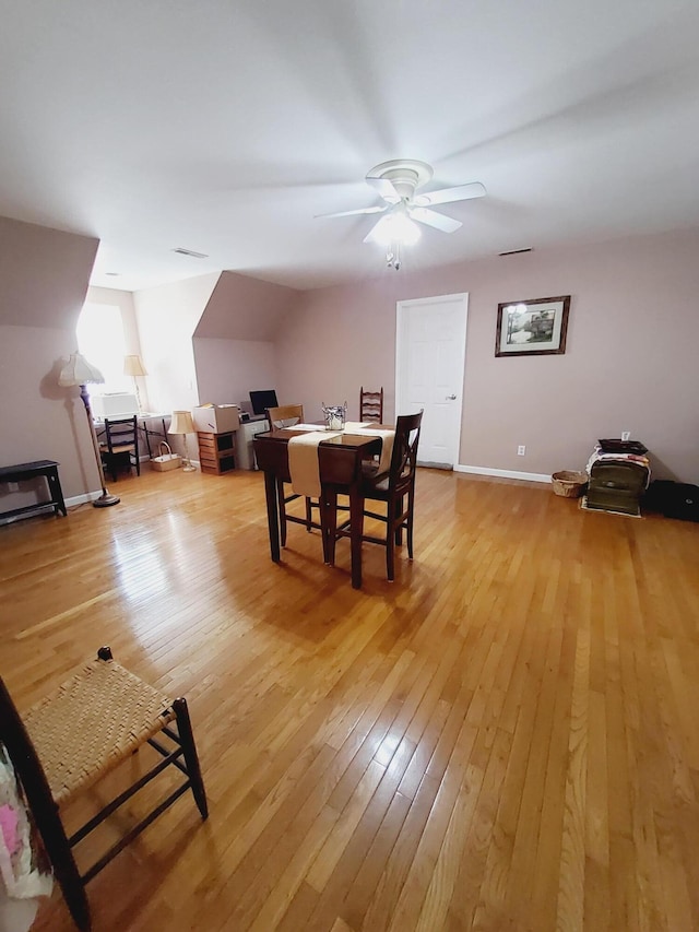 dining room with light wood-type flooring, a ceiling fan, and baseboards