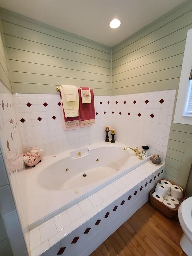 full bathroom featuring a whirlpool tub and wood finished floors