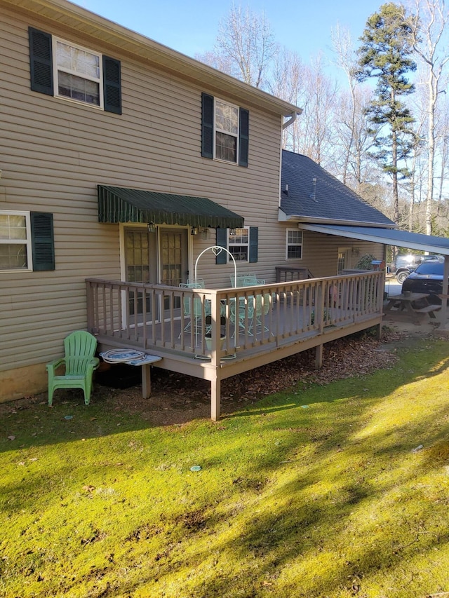 back of house with a deck and a lawn