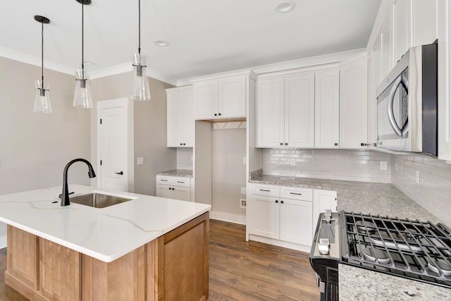 kitchen with white cabinets, stainless steel appliances, and a center island with sink