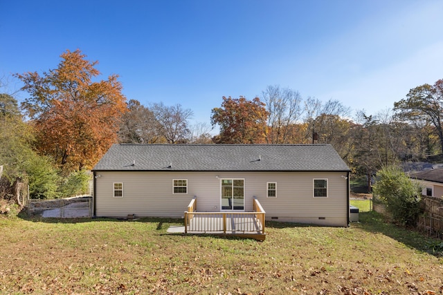 back of house featuring a lawn, a wooden deck, and central AC unit