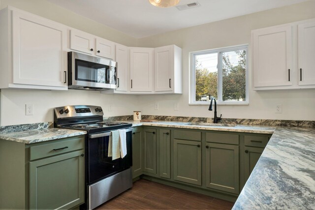 1024 Hurst St, East Ridge, TN 37412 - kitchen featuring appliances with stainless steel finishes, green cabinets, a sink, and dark wood-style flooring