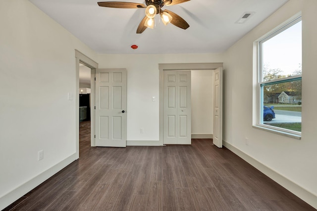 unfurnished bedroom with ceiling fan, dark hardwood / wood-style flooring, and a closet