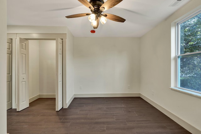 unfurnished bedroom with ceiling fan and dark wood-type flooring