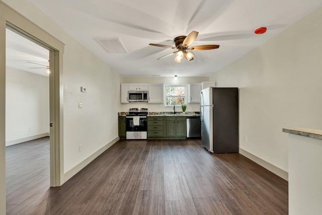 kitchen featuring appliances with stainless steel finishes, green cabinets, sink, dark wood-type flooring, and ceiling fan