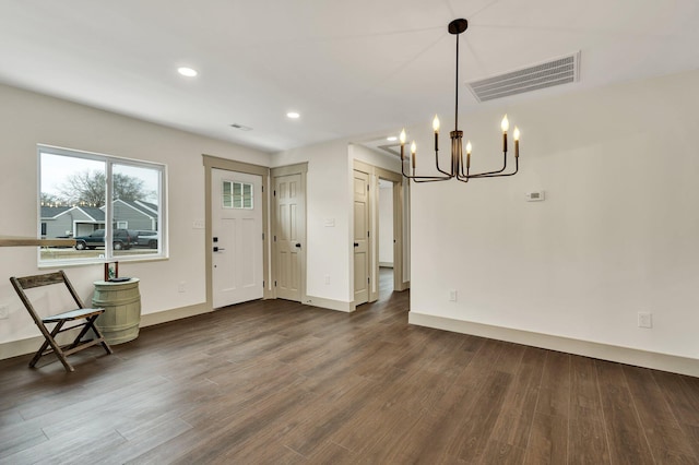 foyer featuring dark hardwood / wood-style flooring and an inviting chandelier