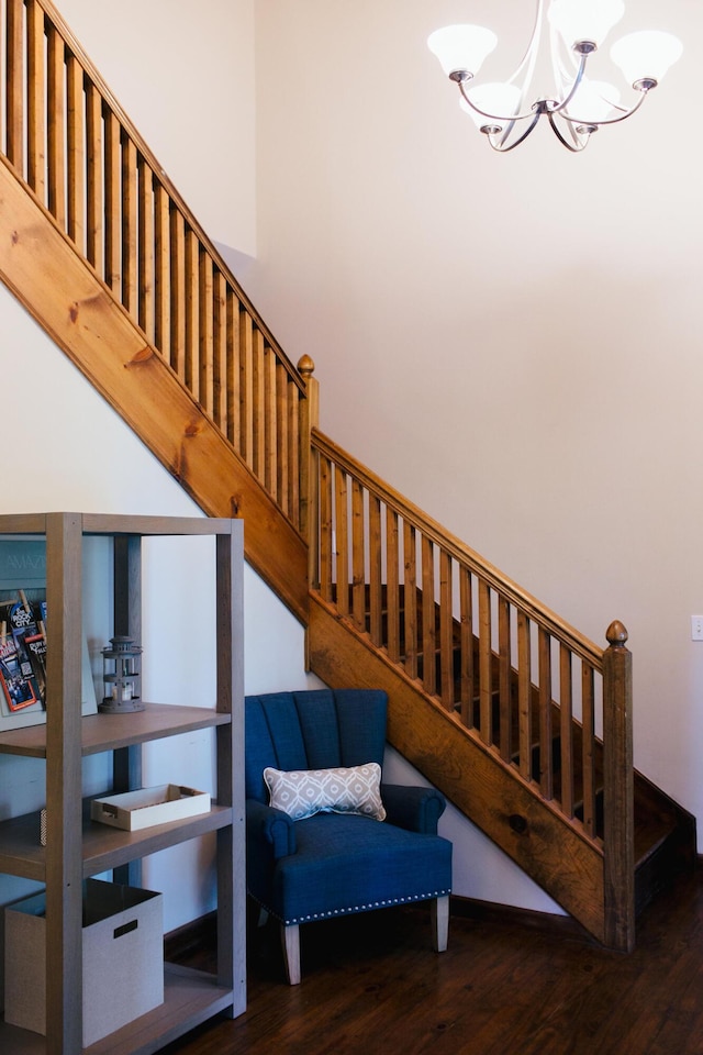 staircase featuring hardwood / wood-style flooring and a notable chandelier