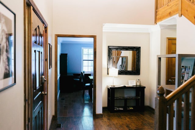 corridor with dark hardwood / wood-style flooring and ornamental molding