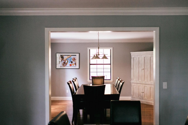 dining area with light wood-type flooring and ornamental molding