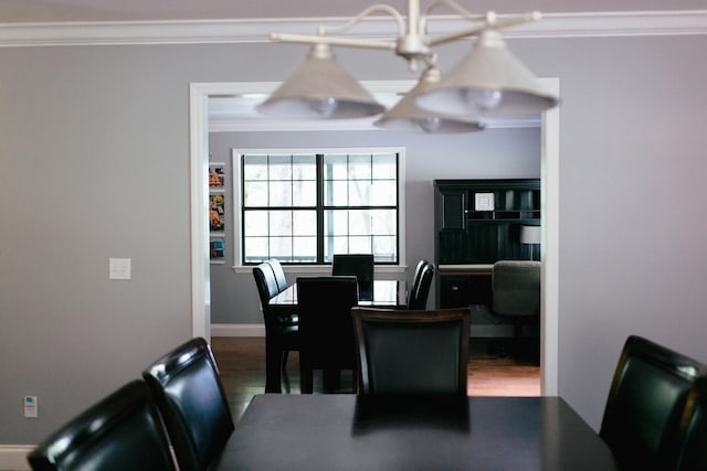 dining area featuring wood-type flooring, an inviting chandelier, and ornamental molding