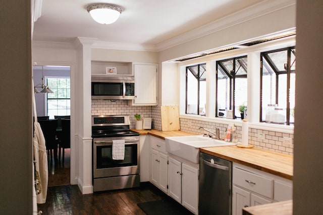 kitchen with white cabinets, butcher block countertops, sink, and stainless steel appliances