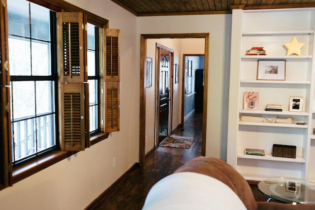 hall featuring dark hardwood / wood-style floors, built in features, wood ceiling, and ornamental molding