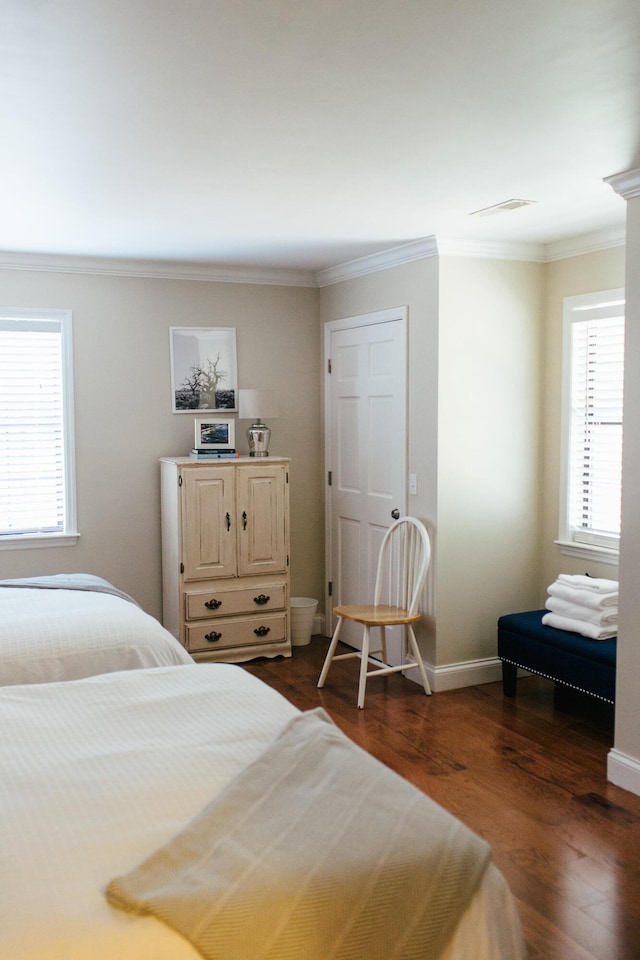 bedroom with dark hardwood / wood-style flooring and ornamental molding