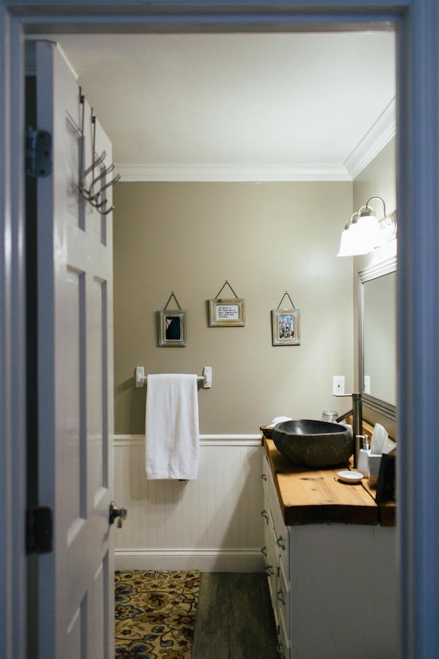 bathroom with vanity, ornamental molding, and hardwood / wood-style flooring