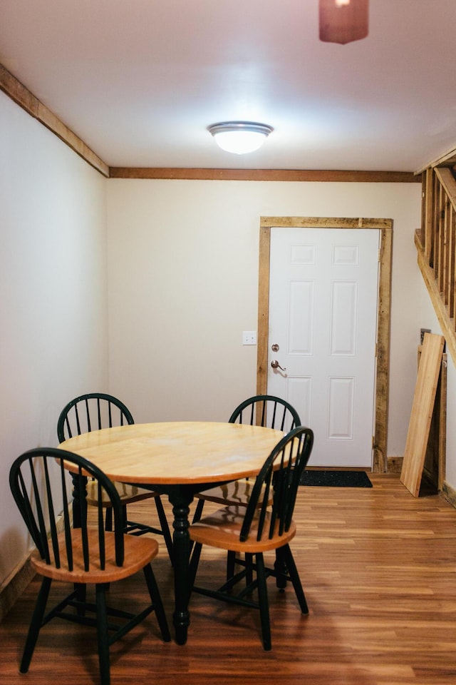 dining area with hardwood / wood-style flooring and ornamental molding