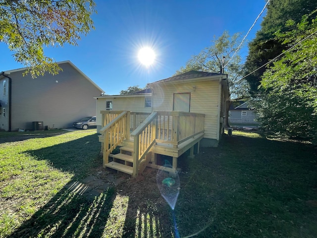 back of house with a deck and a lawn