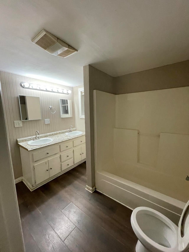 bathroom featuring hardwood / wood-style flooring, vanity, and washtub / shower combination