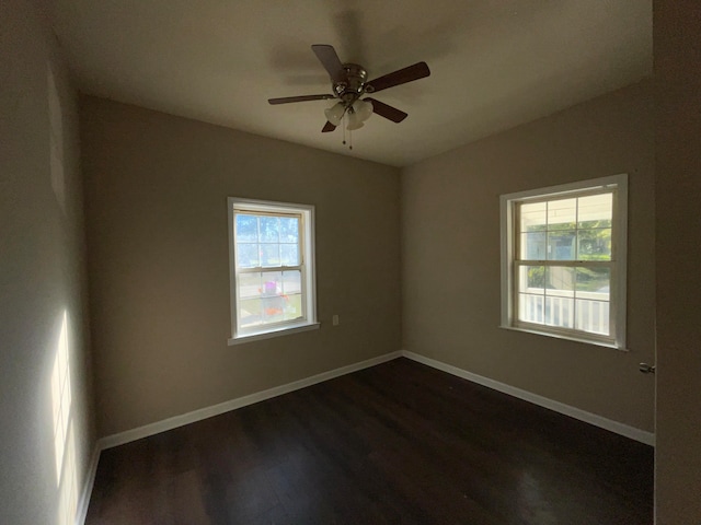 empty room with ceiling fan and dark hardwood / wood-style floors