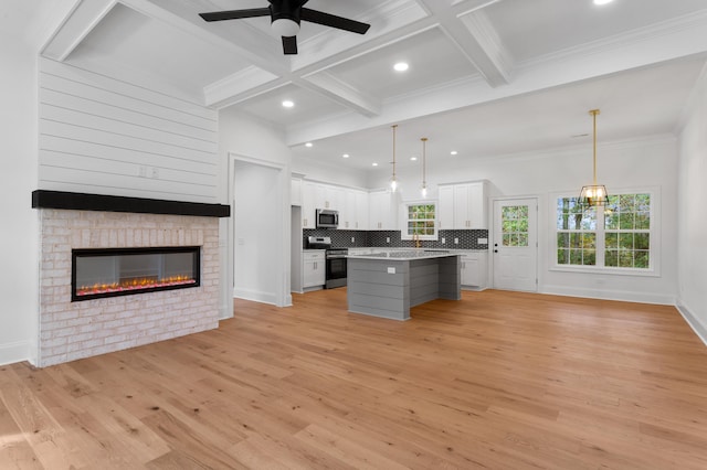 kitchen featuring appliances with stainless steel finishes, white cabinetry, a kitchen island, and light hardwood / wood-style flooring