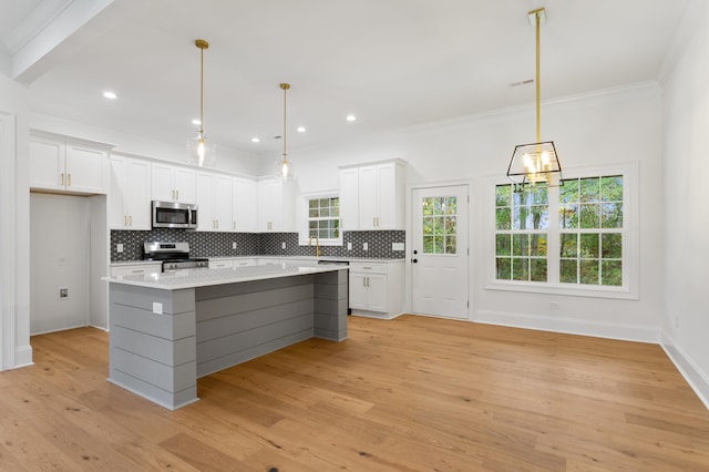 kitchen featuring a center island, white cabinets, stainless steel appliances, and light wood-type flooring