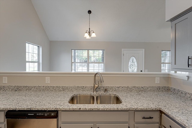 kitchen featuring light stone counters, sink, stainless steel dishwasher, and lofted ceiling