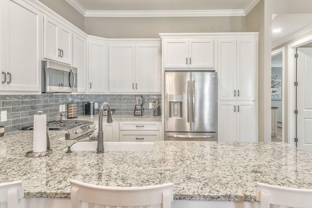 kitchen featuring white cabinetry, a kitchen bar, and appliances with stainless steel finishes