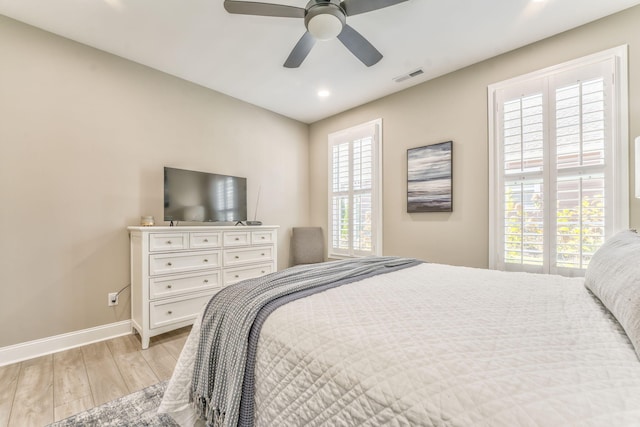 bedroom with multiple windows, ceiling fan, and light wood-type flooring