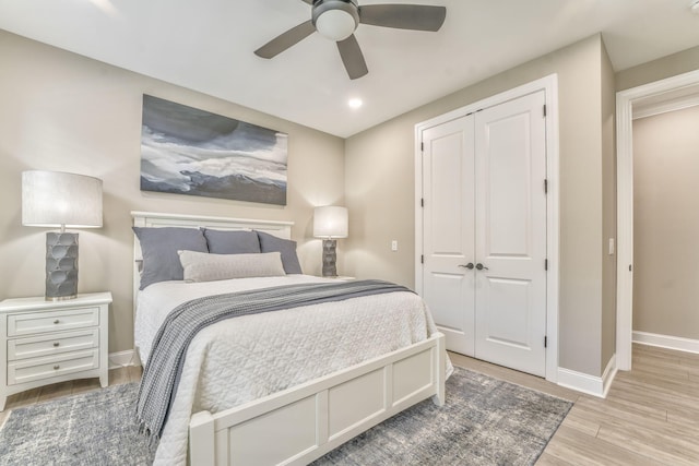 bedroom featuring light hardwood / wood-style flooring, a closet, and ceiling fan