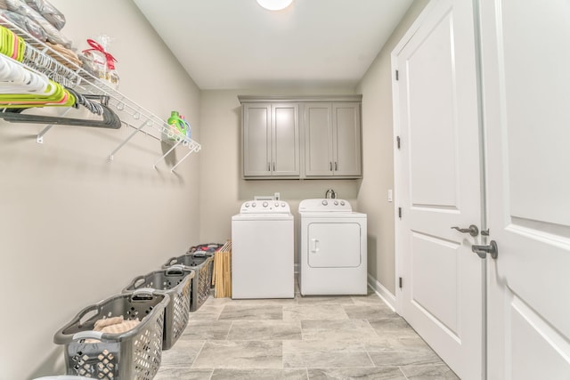 clothes washing area featuring cabinets and independent washer and dryer