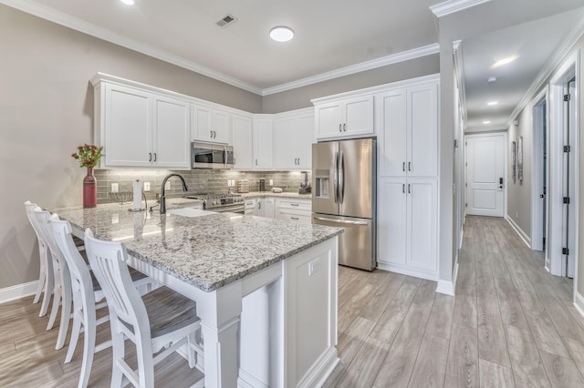 kitchen featuring appliances with stainless steel finishes, white cabinets, and kitchen peninsula