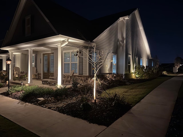 property exterior at twilight featuring a porch