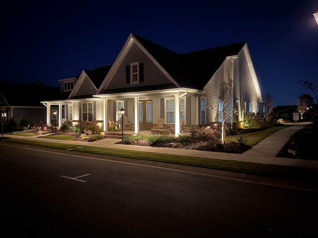 cape cod house featuring covered porch