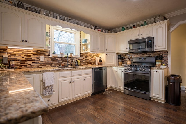 kitchen featuring light stone countertops, sink, stainless steel appliances, dark hardwood / wood-style flooring, and backsplash