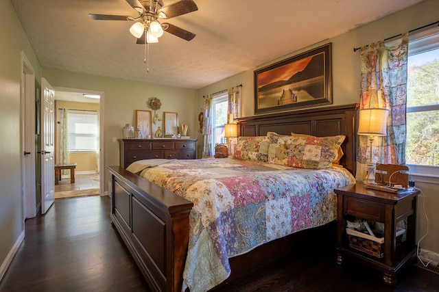 bedroom with ceiling fan, dark hardwood / wood-style flooring, and multiple windows