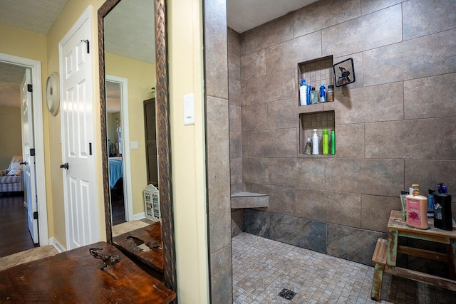 bathroom with a tile shower and hardwood / wood-style flooring