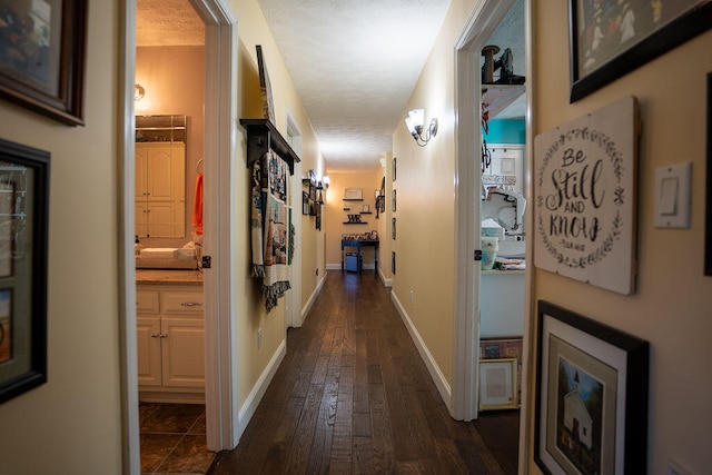 corridor featuring a textured ceiling and dark hardwood / wood-style flooring