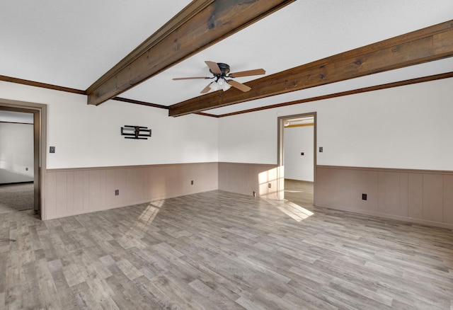 spare room featuring beamed ceiling, ceiling fan, light wood-type flooring, and crown molding