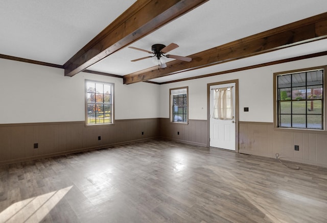 spare room with ceiling fan, crown molding, beamed ceiling, and light hardwood / wood-style floors